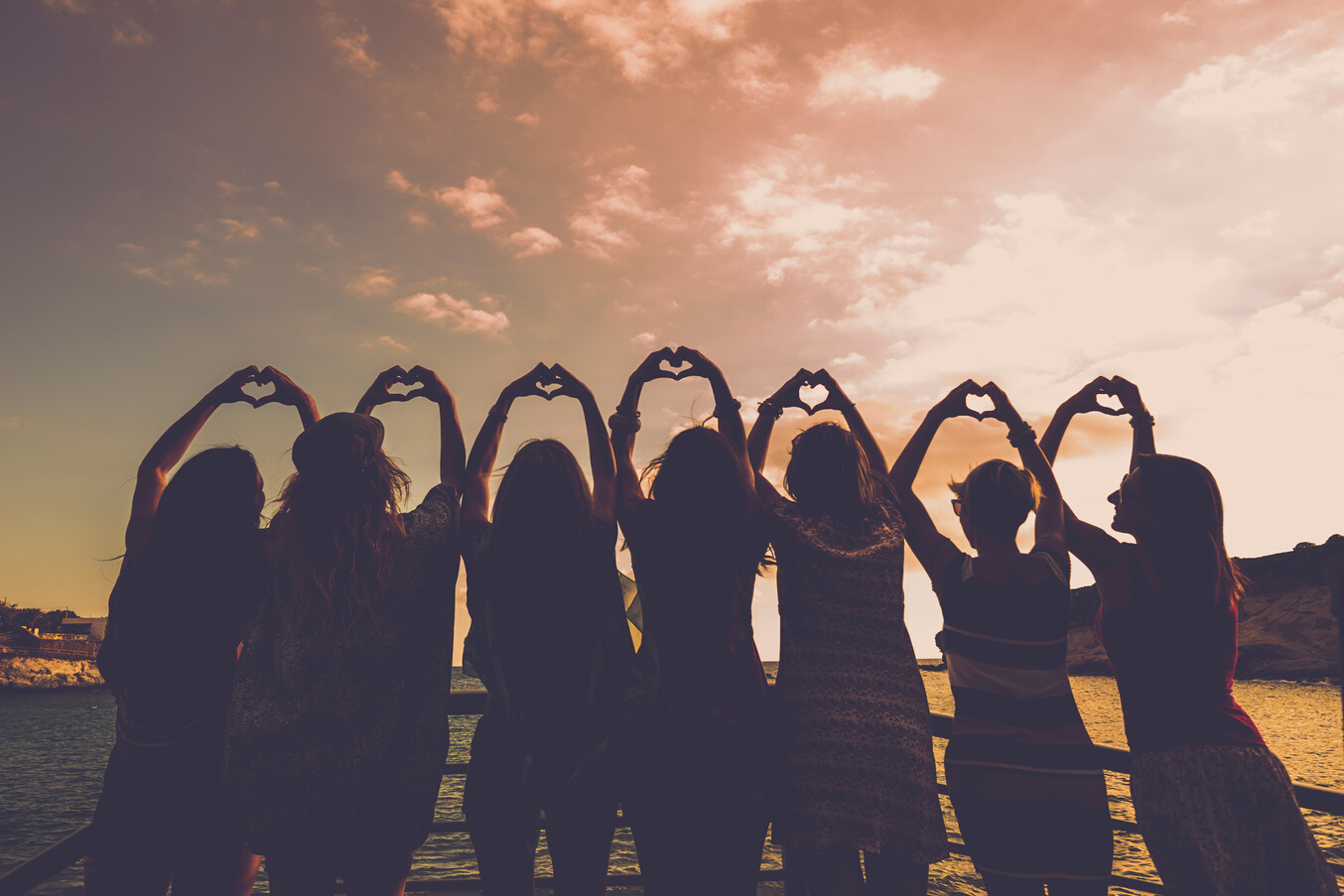 Silhouette of Group of Friends Doing a Heart Hand Gesture 